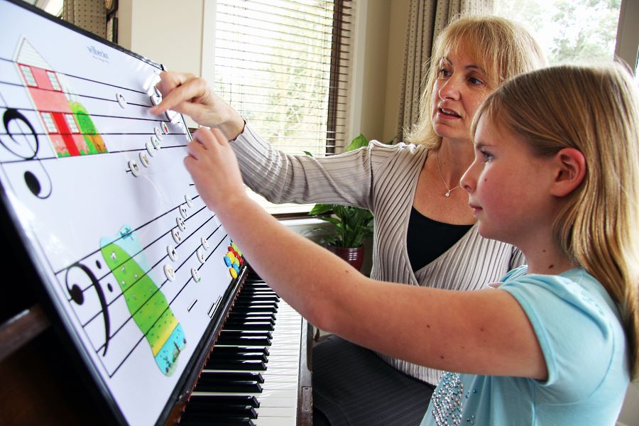Music teacher and child hands-on using Easy Notes magnets and stave
